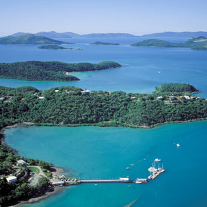Aerial view of Shute Harbour and surrounding coast with the Whitsunday Rent A Yacht base and jetty in the foreground